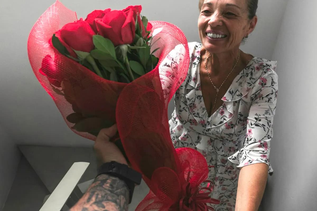 Un mapa estelar en un marco blanco en la pared de un dormitorio sobre flores frescas